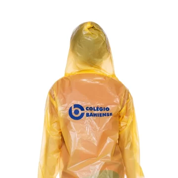 Pessoa de costas usando capa de chuva transparente amarela com logotipo do Colégio Bahiense